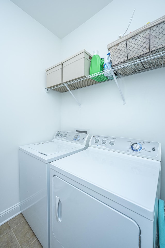 laundry room with washer and clothes dryer, laundry area, baseboards, and light tile patterned floors