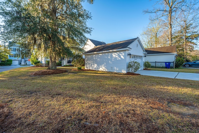 view of property exterior with a lawn, an outdoor structure, and a garage