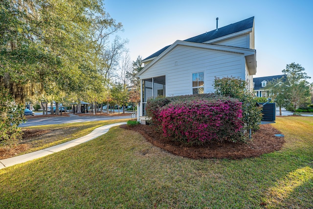 view of side of home with a yard