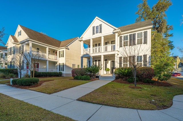 view of front of home featuring a balcony and a front yard