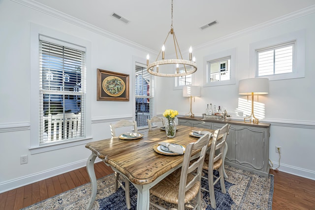 dining room featuring a wealth of natural light, visible vents, dark wood-type flooring, and ornamental molding