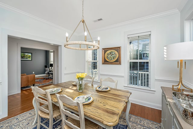 dining room with visible vents, dark wood-type flooring, ornamental molding, baseboards, and a chandelier