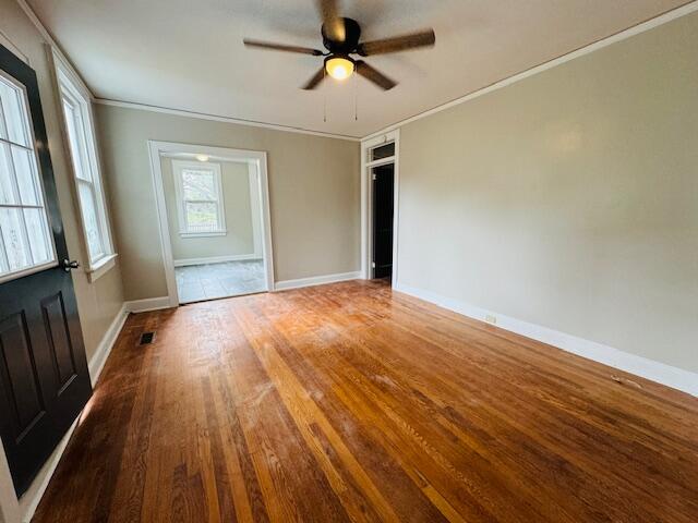 unfurnished room with ceiling fan, hardwood / wood-style floors, and crown molding