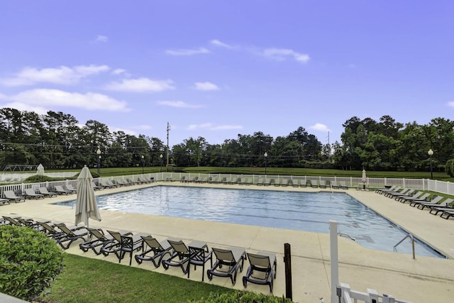community pool with a patio and fence