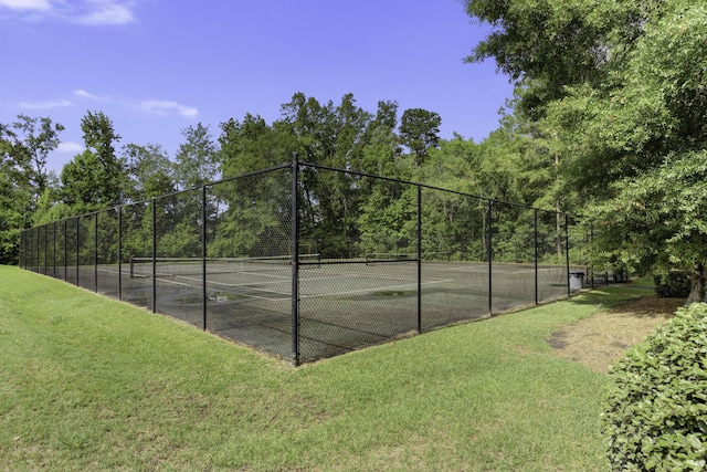 view of sport court featuring a yard and fence