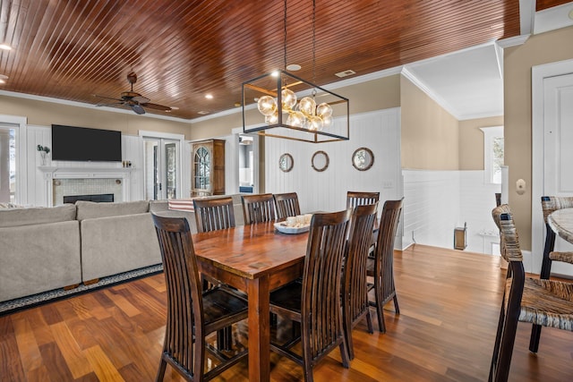 dining area with wood finished floors, crown molding, wood ceiling, and a healthy amount of sunlight