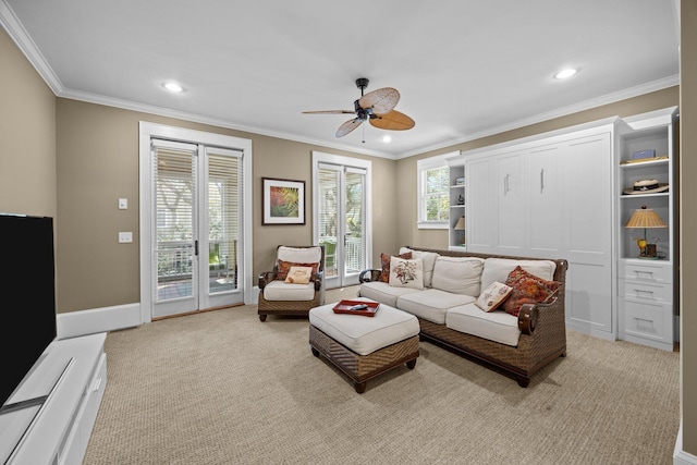 living area with light carpet, ceiling fan, and ornamental molding