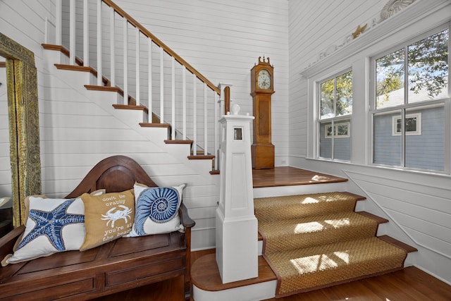 staircase featuring wood walls and wood finished floors