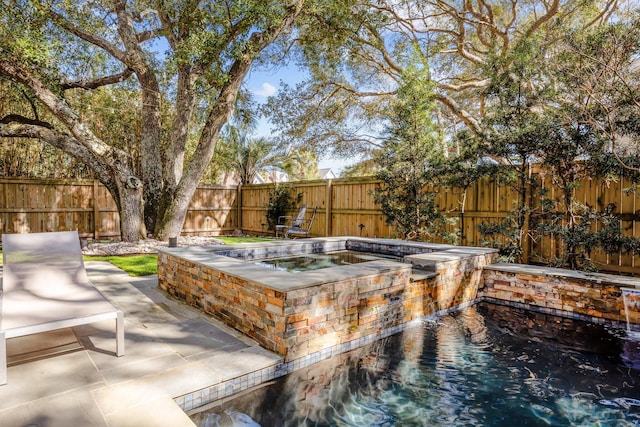 view of swimming pool featuring a patio, an in ground hot tub, and a fenced backyard