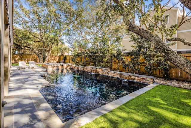 view of pool featuring a patio, a yard, a fenced backyard, and a fenced in pool