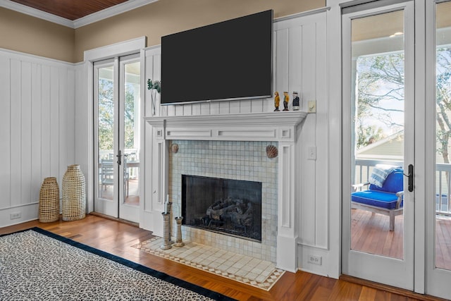 living room with a fireplace, crown molding, and wood finished floors