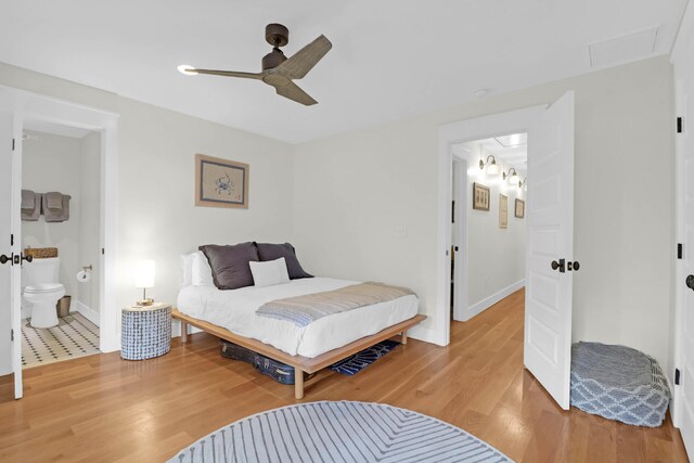 bedroom with ceiling fan, wood-type flooring, and ensuite bathroom