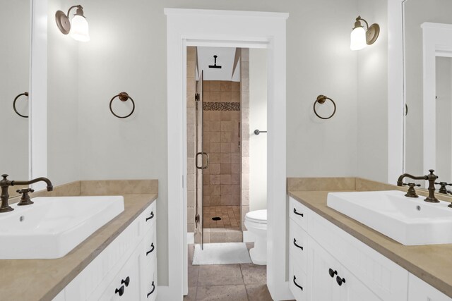 bathroom with vanity, toilet, tile patterned floors, and a shower with shower door