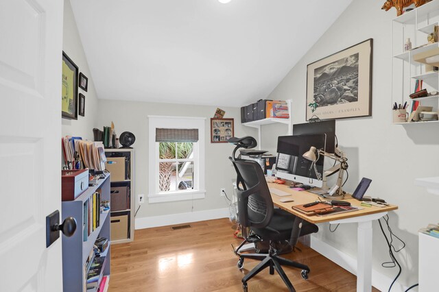 office with vaulted ceiling and light hardwood / wood-style floors