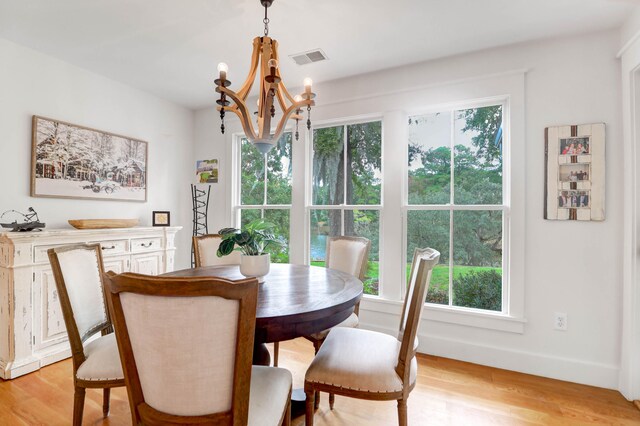 dining space featuring a notable chandelier and light wood-type flooring