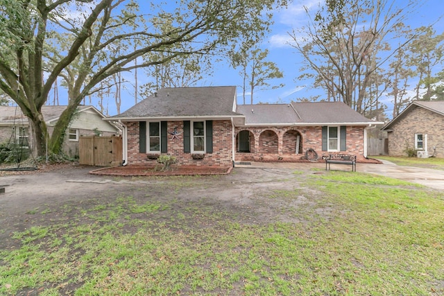 ranch-style home featuring a gate, brick siding, fence, and roof with shingles