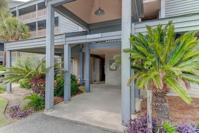 property entrance featuring a balcony and a carport