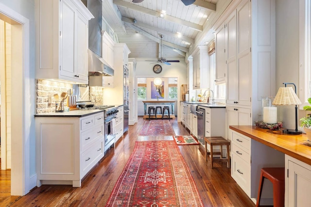 kitchen featuring wood counters, tasteful backsplash, white cabinetry, dark hardwood / wood-style flooring, and stainless steel appliances