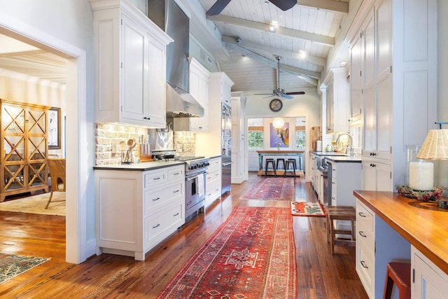 kitchen with tasteful backsplash, white cabinetry, stainless steel range, ceiling fan, and dark wood-type flooring