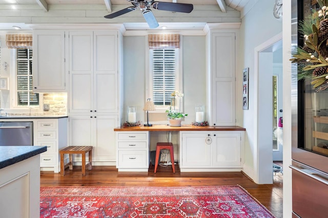 interior space with built in desk, stainless steel dishwasher, white cabinets, and dark hardwood / wood-style flooring