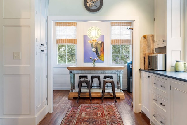 dining space with a healthy amount of sunlight and dark hardwood / wood-style flooring