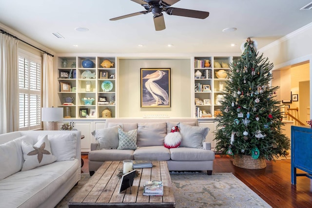 living room featuring ceiling fan, crown molding, wood-type flooring, and built in shelves