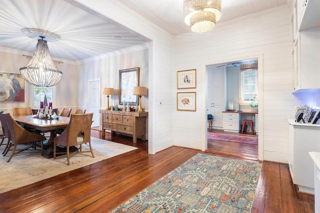 dining room with ornamental molding, dark wood-type flooring, and a chandelier