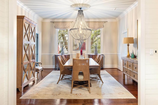 dining space featuring crown molding, dark hardwood / wood-style floors, and a notable chandelier