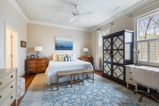 bedroom featuring crown molding, wood-type flooring, and ceiling fan