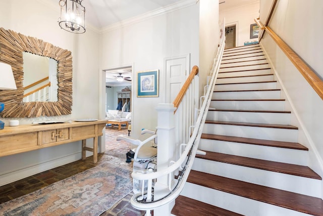 stairway featuring ornamental molding and ceiling fan with notable chandelier