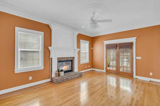 unfurnished living room with a fireplace, crown molding, baseboards, and wood finished floors