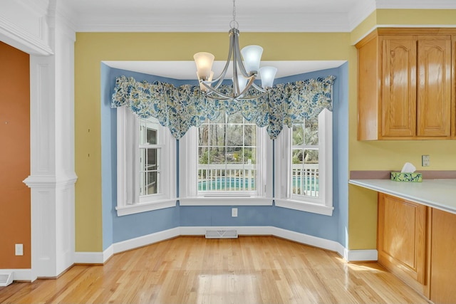 unfurnished dining area with ornamental molding, light wood-type flooring, visible vents, and baseboards