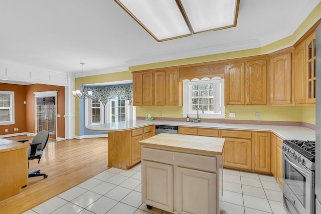 kitchen featuring light tile patterned floors, ornamental molding, a peninsula, stainless steel appliances, and a sink