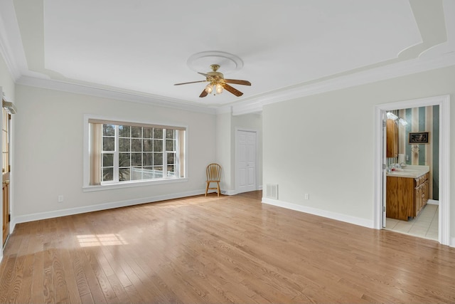 interior space featuring light wood-style floors, visible vents, ornamental molding, and baseboards