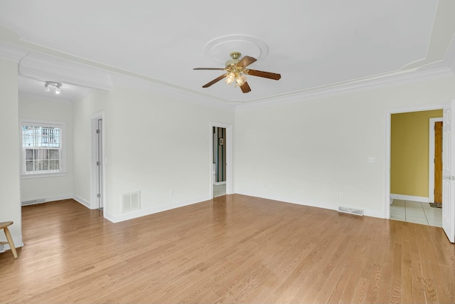 empty room with ceiling fan, ornamental molding, wood finished floors, and visible vents