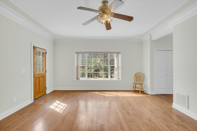 unfurnished room with light wood finished floors, baseboards, visible vents, and ornamental molding