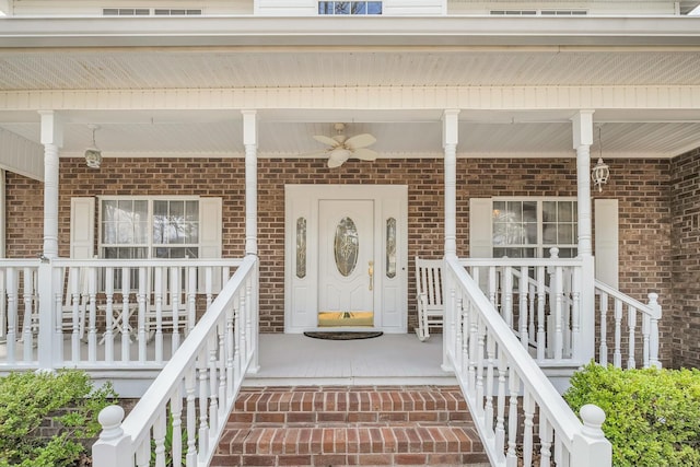 view of exterior entry featuring covered porch and brick siding