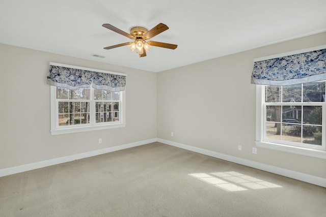 unfurnished room featuring a healthy amount of sunlight, baseboards, and visible vents