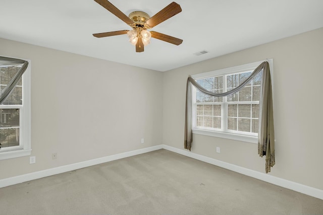 empty room featuring ceiling fan, carpet, visible vents, and baseboards