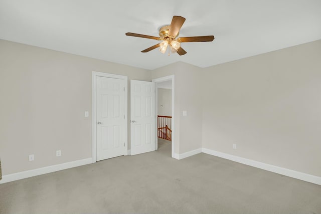 unfurnished bedroom with baseboards, a ceiling fan, and light colored carpet