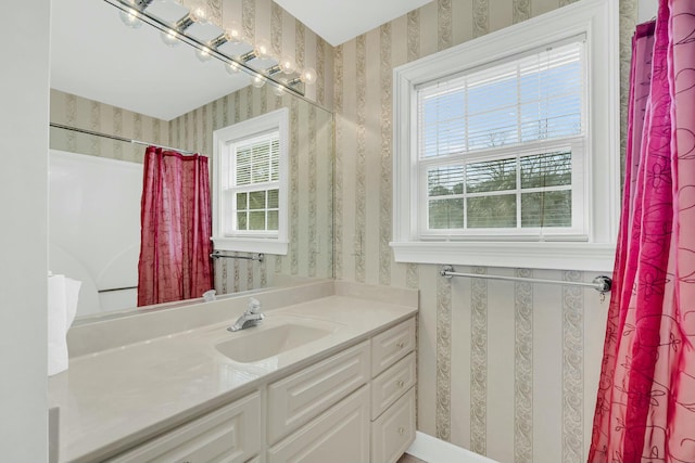 full bath featuring vanity and wallpapered walls