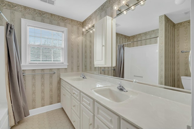 bathroom with wallpapered walls, baseboards, visible vents, and a sink