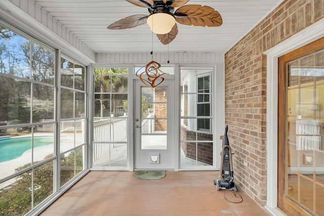 unfurnished sunroom with a ceiling fan