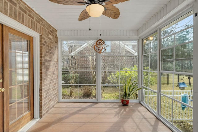 unfurnished sunroom with a ceiling fan and a wealth of natural light