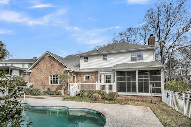 rear view of house with a fenced in pool, a chimney, a sunroom, crawl space, and fence