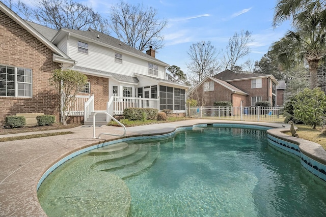 view of pool with a sunroom, a patio area, fence, and a fenced in pool