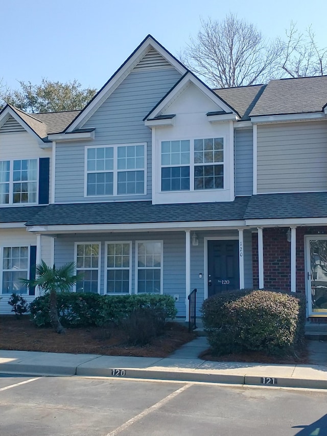 townhome / multi-family property with brick siding and roof with shingles