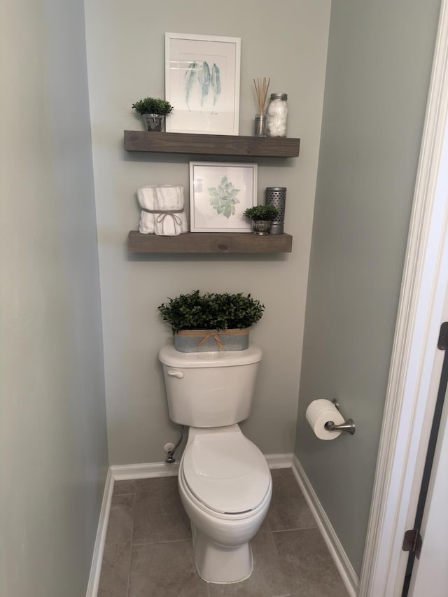 bathroom with baseboards, toilet, and tile patterned floors