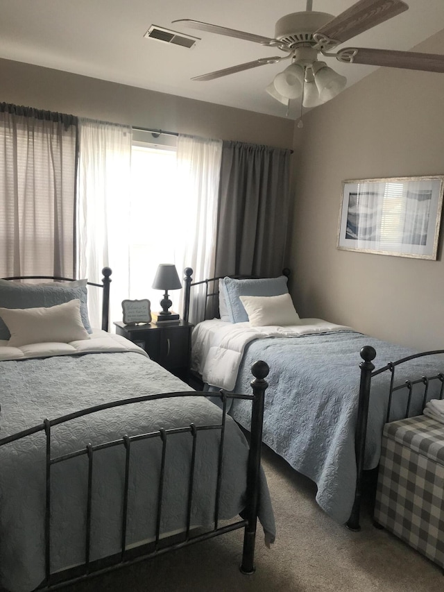 bedroom featuring ceiling fan, carpet floors, vaulted ceiling, and visible vents