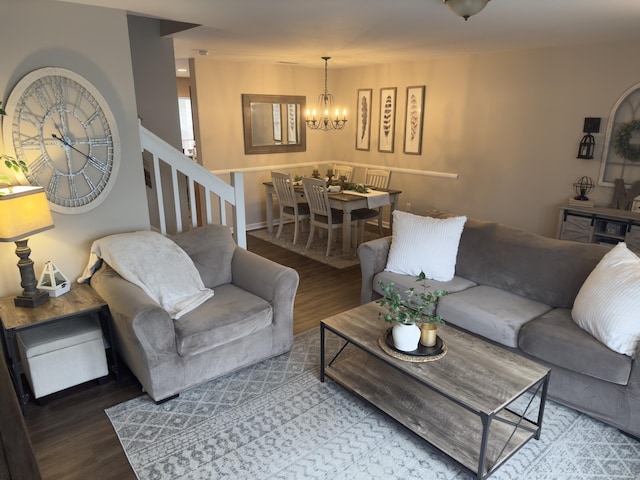 living area featuring stairway, wood finished floors, and a notable chandelier